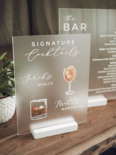 there are two signs on the table that say signature cocktails