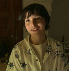 a person standing in front of a table with food on it and smiling at the camera