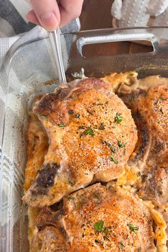 a person is cutting up some meat in a casserole dish with cheese and herbs