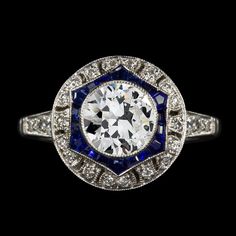 an antique diamond and blue sapphire ring with diamonds around the band, set in 18k white gold