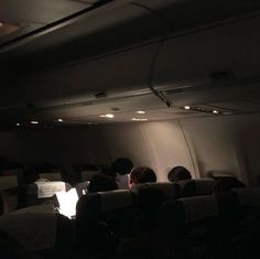 people sitting in an airplane watching something on the screen