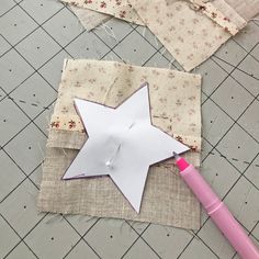 a piece of fabric is laying on the floor next to a star shaped pin cushion