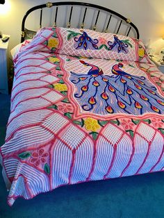 a bed with a pink and blue bedspread on it