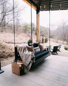 a porch swing with pillows and blankets on it