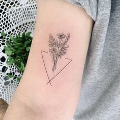 a woman's arm with a flower tattoo on the left side of her arm