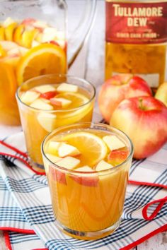 two glasses filled with apple cider punch on top of a blue and white towel