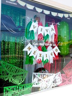 an image of mexican themed window display in the store front windows with flags and bunting