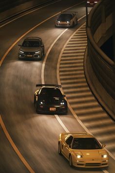 three cars driving down a highway at night time with lights on and one car in the foreground