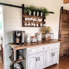 a kitchen with white cabinets and wooden counter tops, coffee maker on the far wall