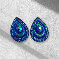 These elegant earrings are handcrafted with rhinestones and flatback beads, measuring 18x25mm in size. They are perfect for occasions such as weddings or everyday wear. Color: Blue Size: 18x25mm Brand: PAIRES Teardrop Rhinestone Earrings For Gift, Teardrop Crystal Earrings With Rhinestones, Teardrop Crystal Earrings With Rhinestones For Gift, Crystal Teardrop Earrings With Rhinestones For Gift, Gift Crystal Teardrop Earrings With Rhinestones, Crystal Clip-on Earrings With Rhinestones For Gift, Beaded Earrings Native, Elegant Earrings, Jewelry Earrings Studs