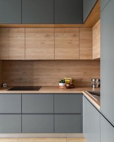 a kitchen with grey cabinets and wooden counter tops