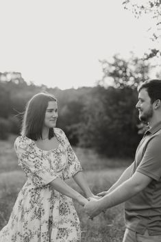 a man and woman holding hands in a field