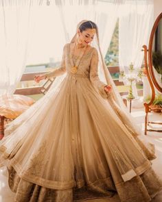 a woman in a wedding dress standing near a window