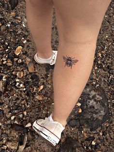 a person with a bee tattoo on their leg