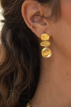 -18k gold plated earrings with molten brushed gold coins. -Measures 1" -Handmade in Brazil -18k gold plated over brass