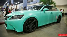 a blue car is parked in a showroom