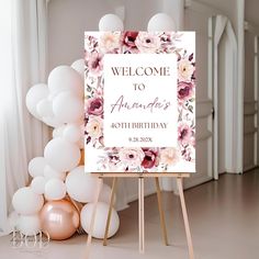 a welcome sign sitting on top of a wooden easel in front of some balloons