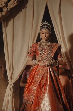 a woman in an orange and gold wedding dress