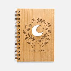 a wooden notebook with the moon and leaves on it