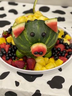 a bowl filled with fruits and vegetables shaped like a mouse on top of a plate