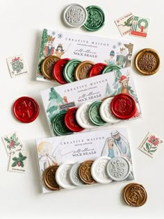 several different types of buttons and stamps on a white surface with christmas greetings in the background