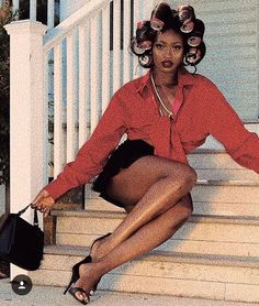 a woman sitting on the steps with her hair in rollers and holding a purse