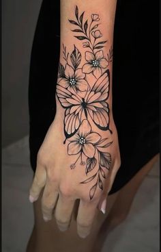 a woman's arm with flowers on it and the wrist is shown in black ink