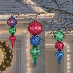 christmas ornaments hanging from the ceiling in front of a house