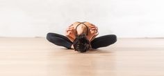 a woman sitting on the floor with her hands behind her head