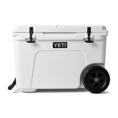 the yeti cooler is white and has black wheels on it, with an emblem that reads