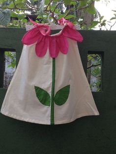 a dress made to look like a flower with green leaves on the front and pink petals on the back