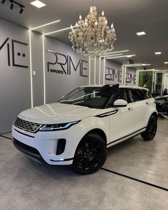 a white range rover parked in a showroom