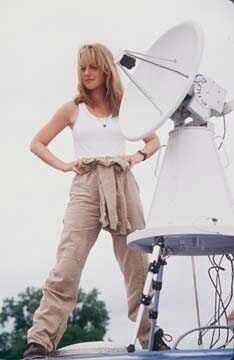 a woman standing on top of a satellite dish