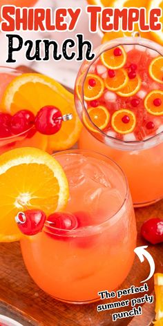 two glasses filled with oranges and cherries on top of a wooden cutting board