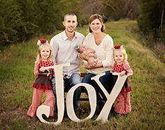 a family sitting on a bench with the word joy spelled out