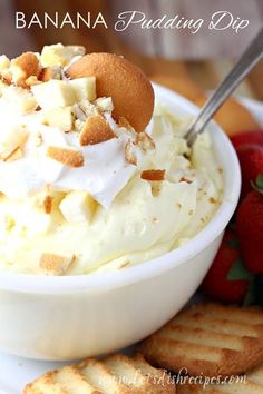 banana pudding dip in a white bowl with crackers and strawberries on the side