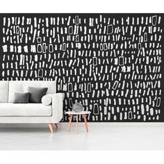 a white couch sitting in front of a black and white wall