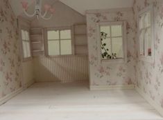 an empty room with pink flowers on the walls and white trim around the window sill