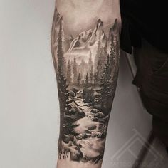 a man with a mountain landscape tattoo on his arm