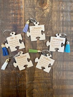 four pieces of puzzle with the names of each piece on them and two keychains attached