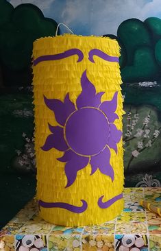 a yellow and purple paper lantern sitting on top of a table next to a painting