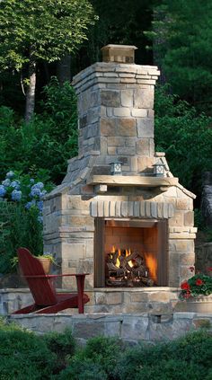 an outdoor fireplace with chairs around it