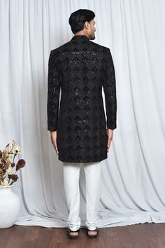 Black velvet sherwani with mandarin collar, all over checkered pattern, tonal sequin and cut dana embroidery. Paired with white churidar.
Components: 2
Pattern: Embroidered
Type Of Work: Cut Dana and Sequin Work
Neckline: Mandarin Collar
Sleeve Type: Full Sleeves
Fabric: Sherwani: Velvet, Churidar: Poly Viscose
Color: Black
Other Details: 
Closure:
Sherwani: Front concealed placket
Churidar: Front drawstrings and concealed zip
Note: The pocket square worn by the model is not for sale
Occasion: C Velvet Churidar, Velvet Sherwani, Black Sherwani, White Churidar, Churidar, Full Sleeves, Checkered Pattern, Mandarin Collar, Pocket Square