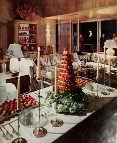 a room filled with lots of tables covered in candles and fruit on top of it