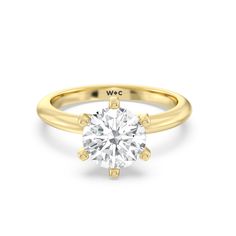 a yellow gold engagement ring with a round diamond