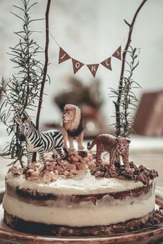 a cake with zebras, lions and giraffe figurines on it