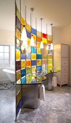 a bathroom with an artistic glass wall behind the sink and bathtub in front of it