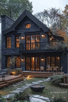 a black house with lots of windows and steps leading up to the front porch area