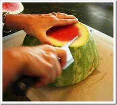 a person cutting up a watermelon with a knife