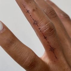 a person's hand with a small star tattoo on the middle finger and an arrow in the middle